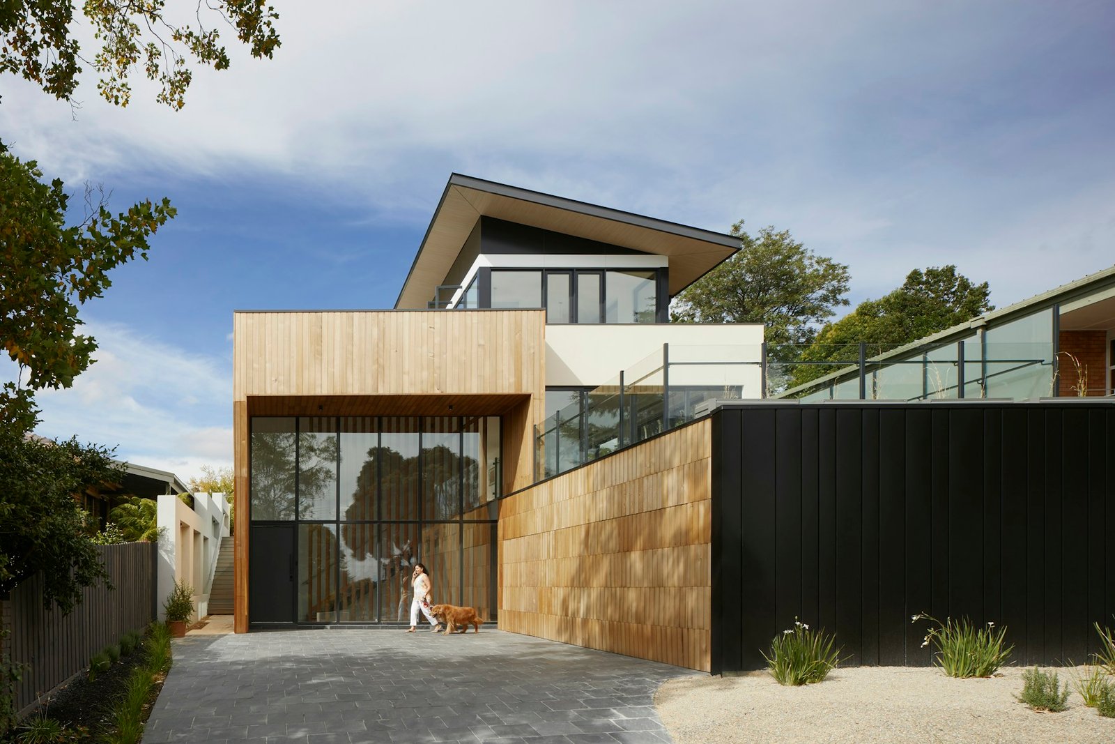 Modern white residence nestled against a green hillside